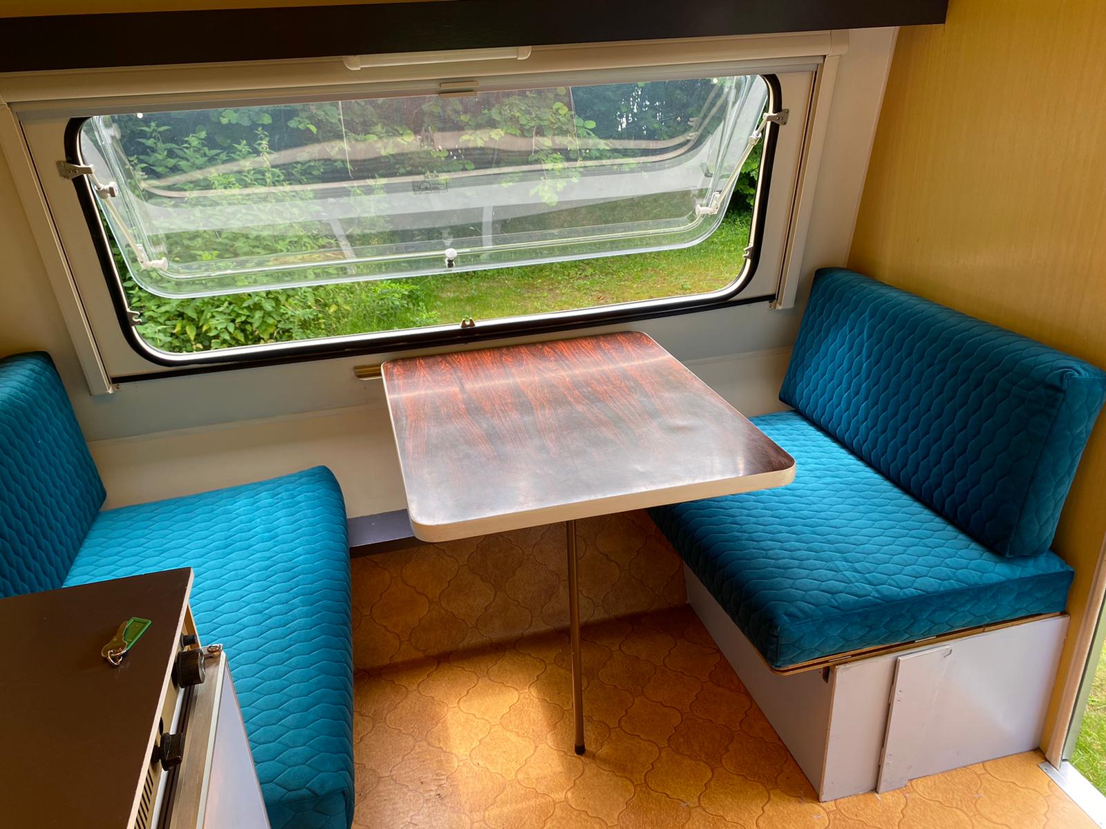 blauwe velvet kussen met ruit patroon in eethoek in caravan