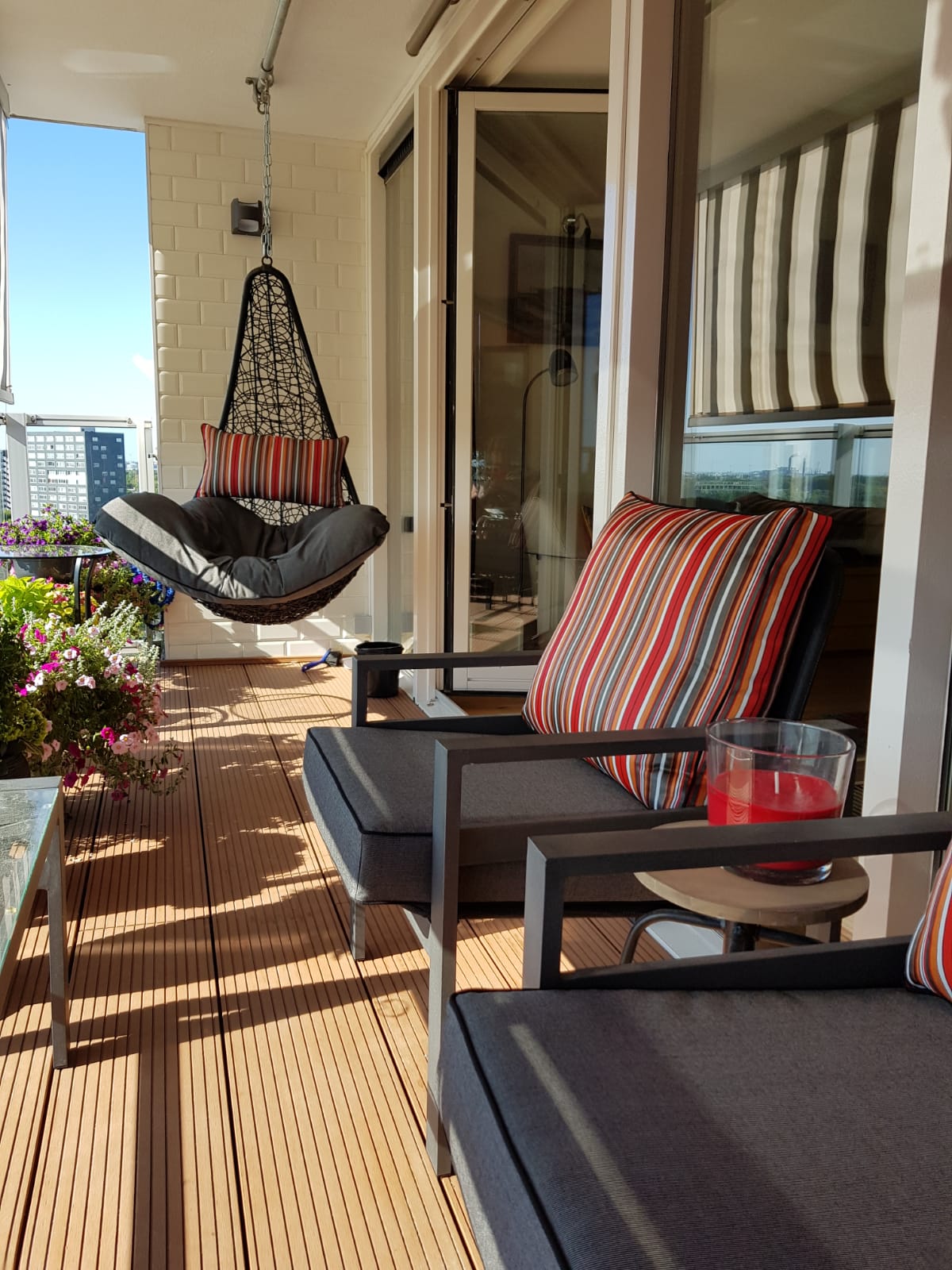 grijze strakke kussens op maat met rode gestreepte plofkussens op een balkon 