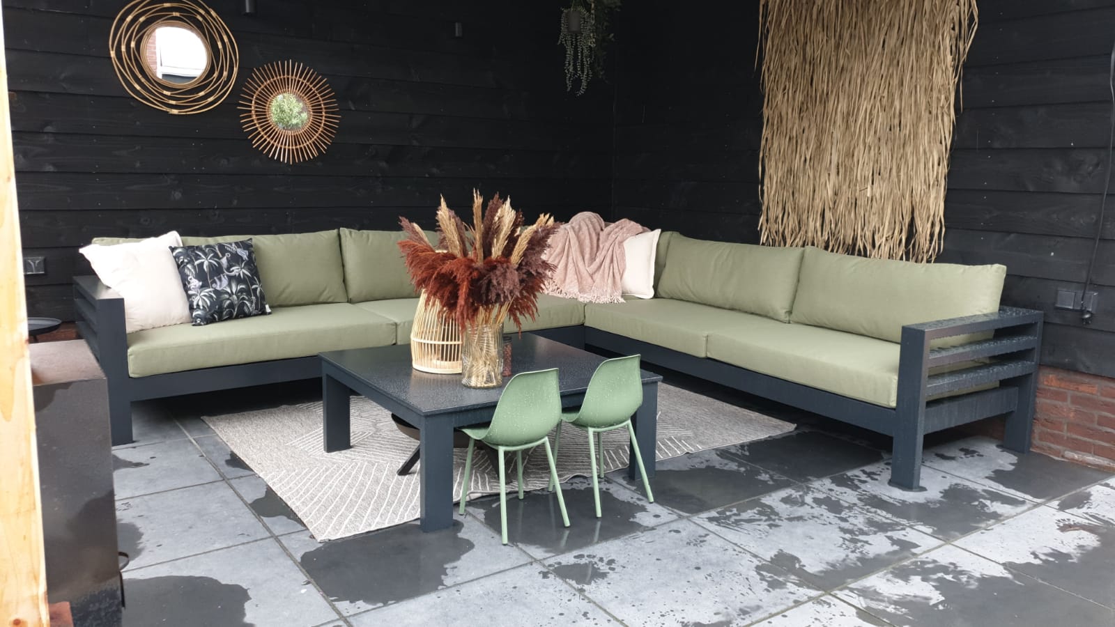 Groene strakke kussens met plof rugkussens op een zwarte bank