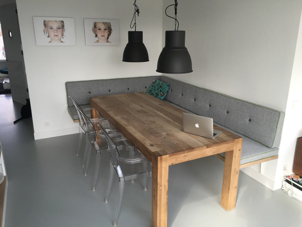 Grijze strakke kussens met groene bies en knopen op een eetkamer bank