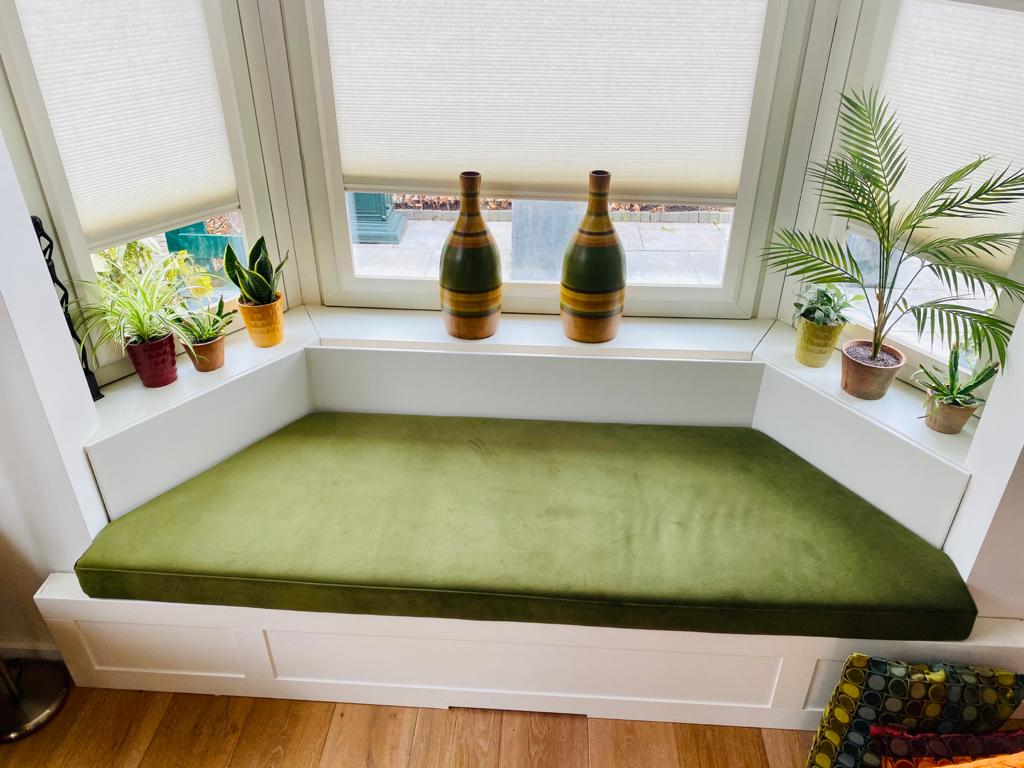 groen kussen op bank in erker